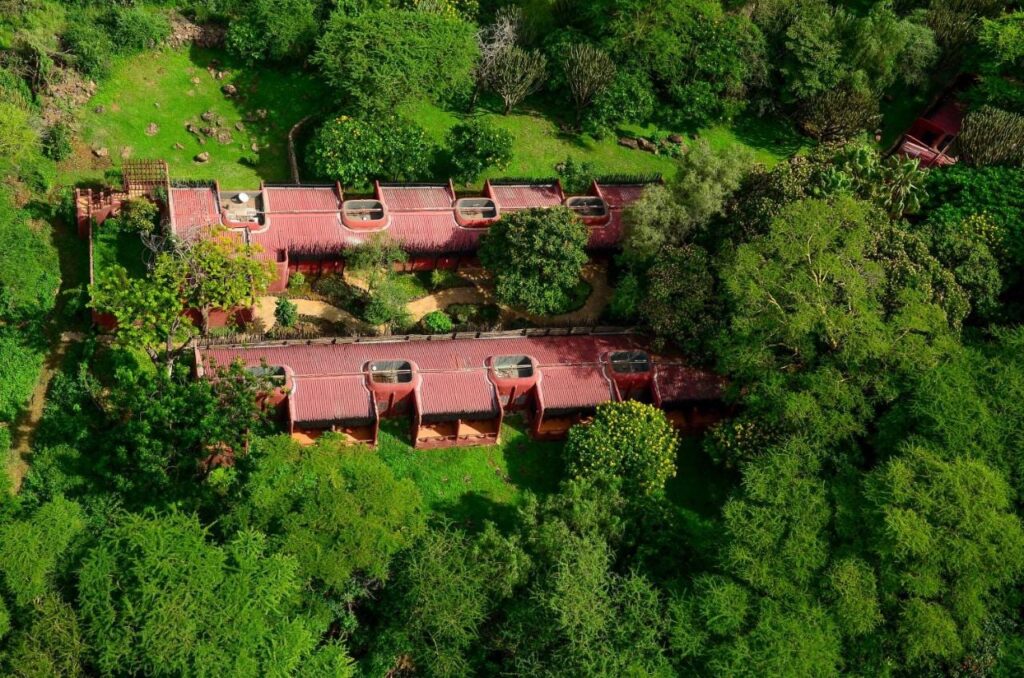 Las dos alas de tejados rojos del Amboseli Serena Safari Lodge vistas desde el aire, entre los árboles