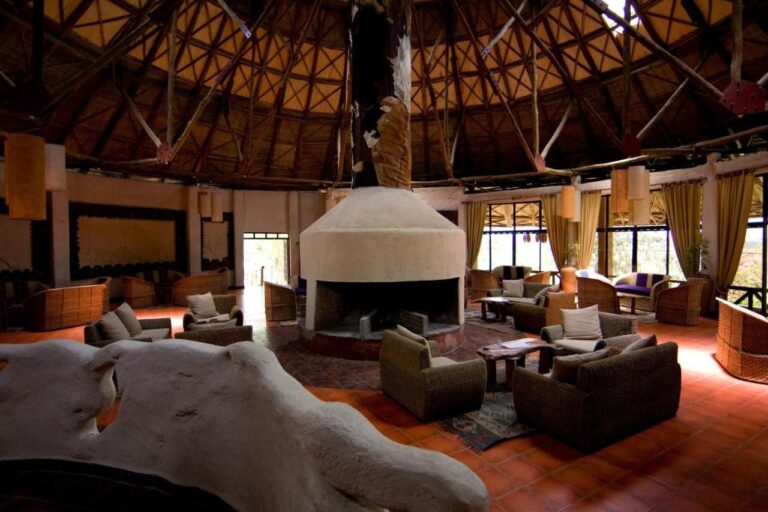Un salón bajo una estructura redonda de madera, con sillones alrededor de una chimenea blanca
