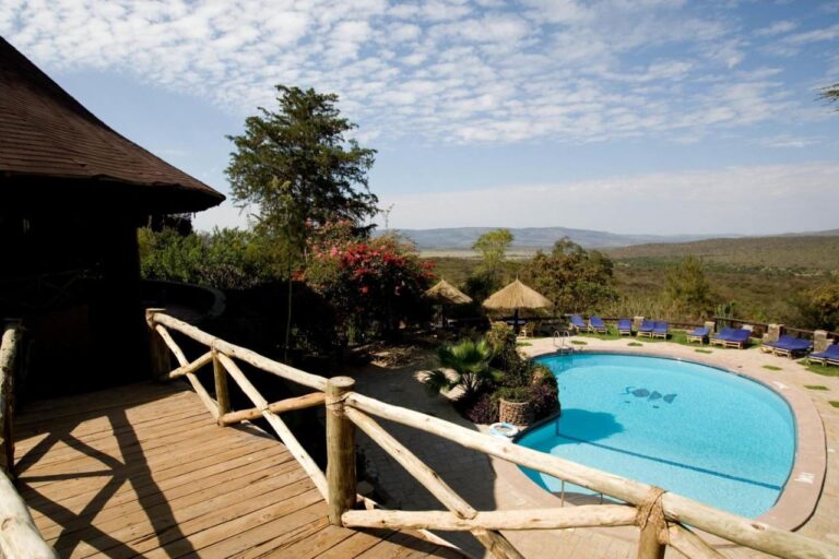 La piscina del Mara Sopa Lodge vista desde una terraza de madera, frente a la sabana y las colinas