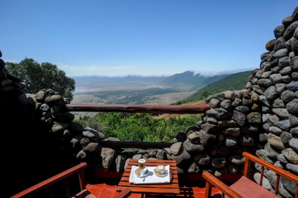 Dos cafés en un balcón del Ngorongoro Serena Safari Lodge, entre muros de piedra, encima del cráter