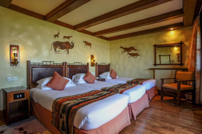 Una habitación triple bajo vigas de madera, con animales pintados en las paredes
