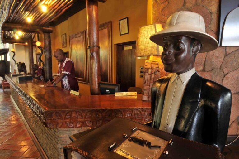 La recepción, con un mostrador tallado y la estatua de madera de un hombre con salacot