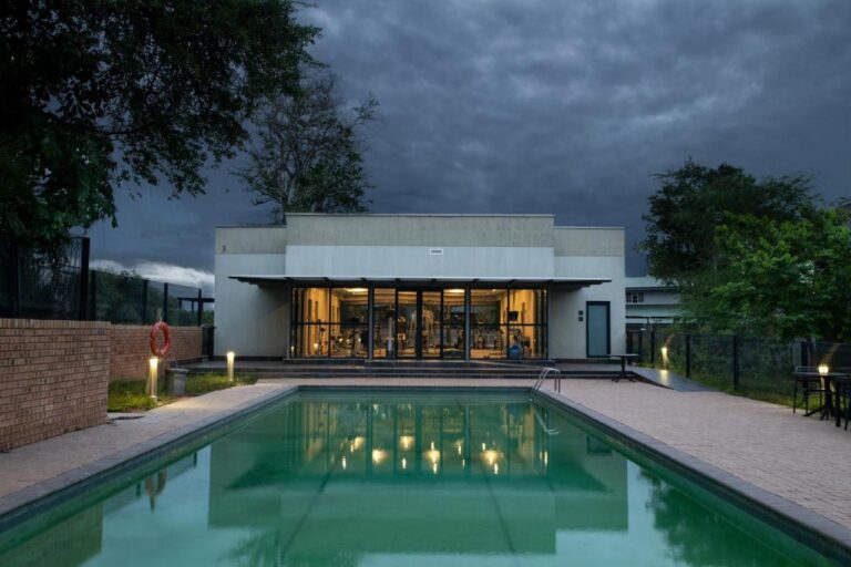 La piscina al aire libre delante del gimnasio acristalado, bajo un cielo de tormenta