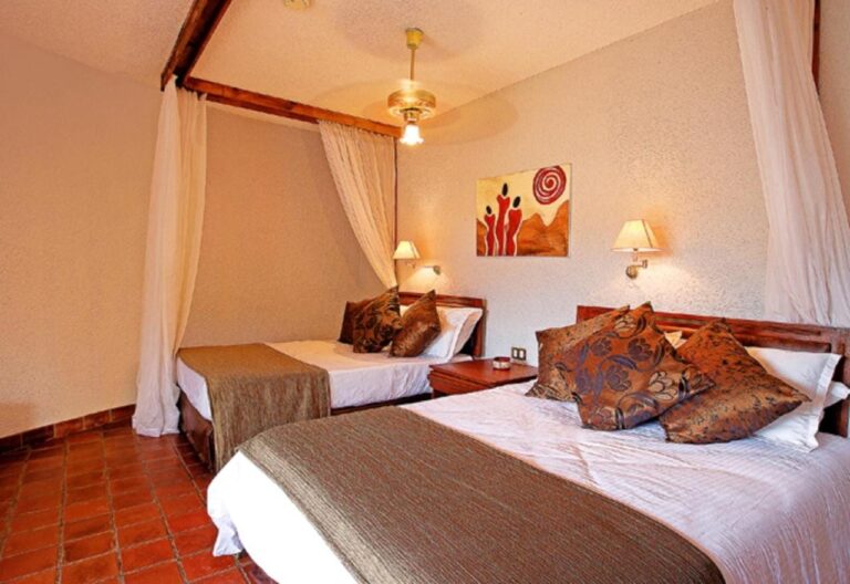 Una habitación con dos camas, visillos y un ventilador de techo