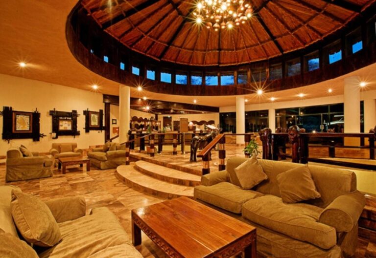 Un salón circular con sofás, bajo una cúpula de madera